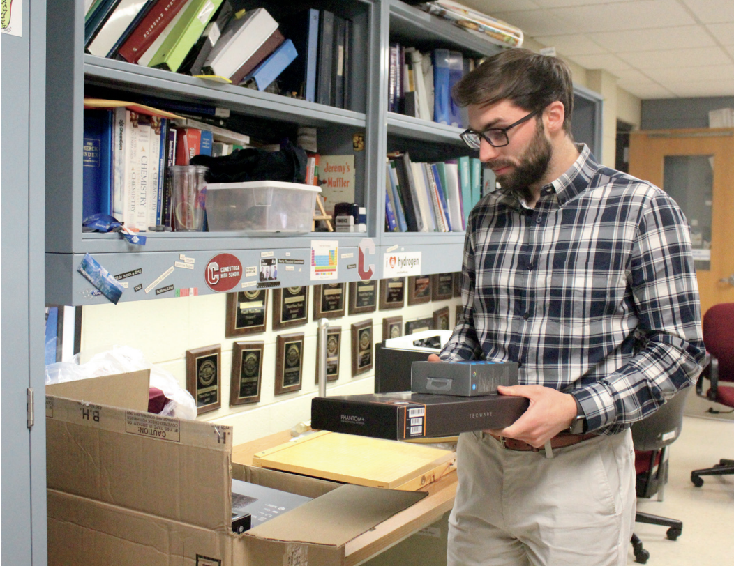 Exciting equipment: Club adviser and biology teacher Derek Bosworth unpacks new esports equipment. Bosworth took charge of deciding what equipment the club will need for success this year.